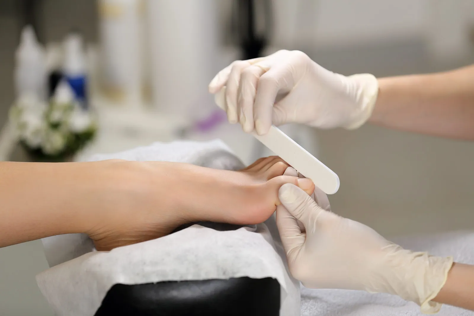 Fußpflege mit Handschuhen und Nagelfeile