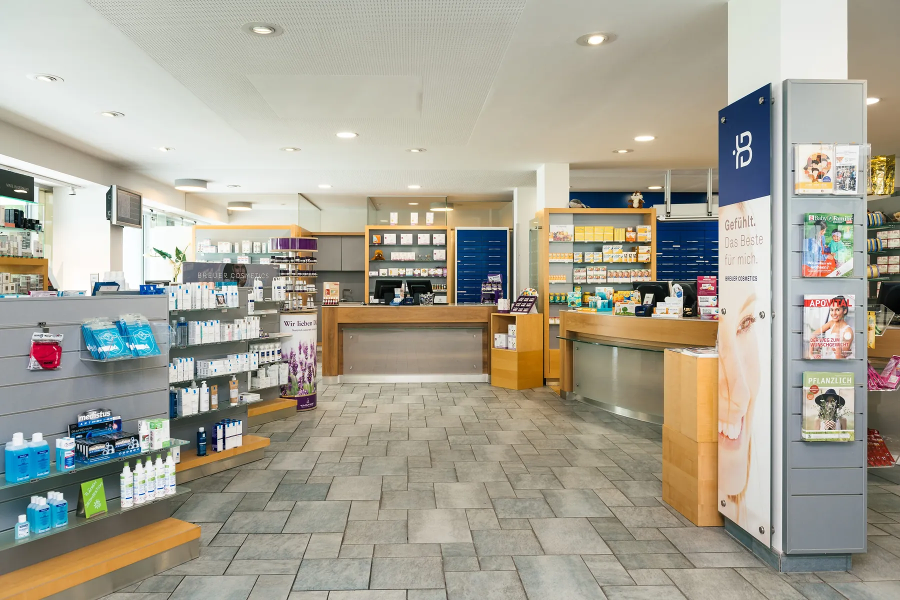 Heller Verkaufsraum der Reichenauer Apotheke mit Holztheken, Regalen und Steinboden