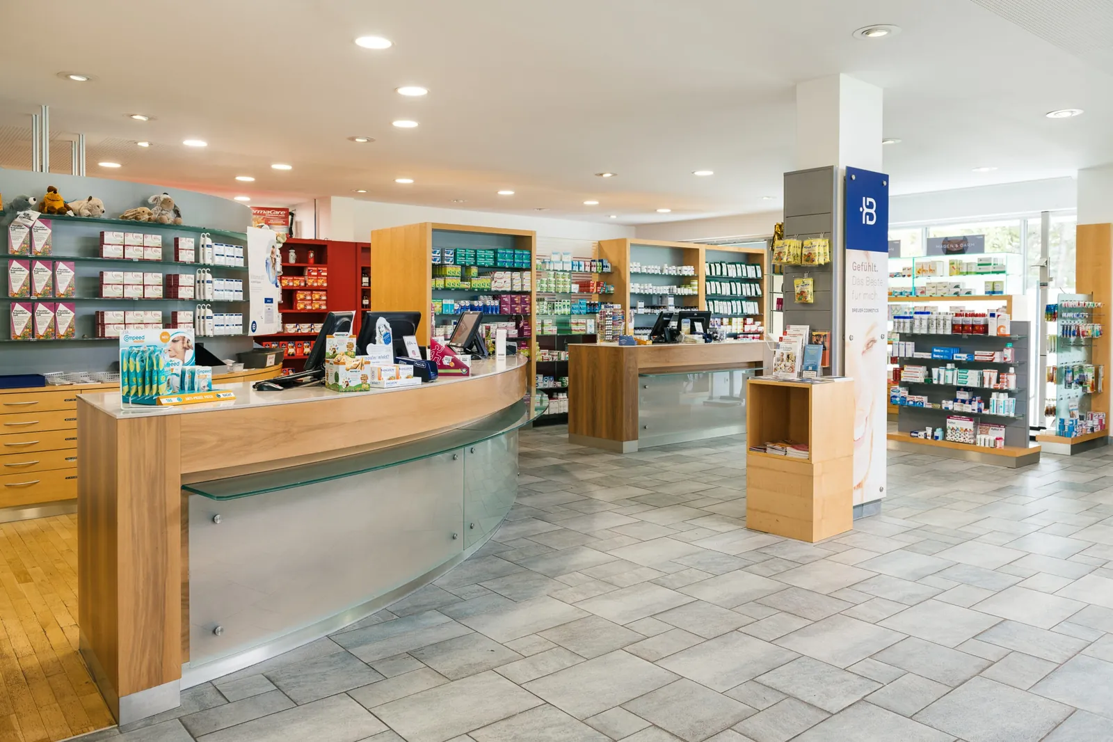 Geschwungene Holztheke mit mehreren Beratungsplätzen in der Reichenauer Apotheke